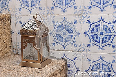 Decorative Moroccan lantern on stone stairs. Vintage blue Moroccan tiles. Portuguese azulejos. Decorative wall. Festive Stock Photo