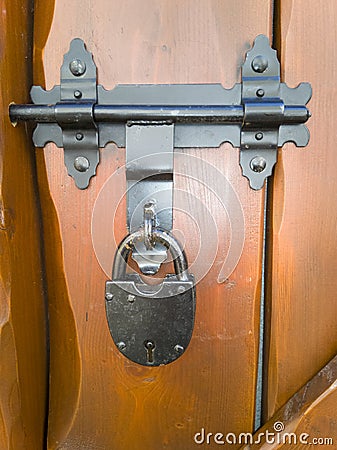 An decorative padlock in a wooden door Stock Photo