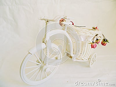 decorative toy bike and dried rose buds Stock Photo