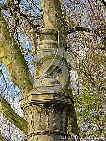 Decorative vase sculpture on top of a pillar with laurels Stock Photo