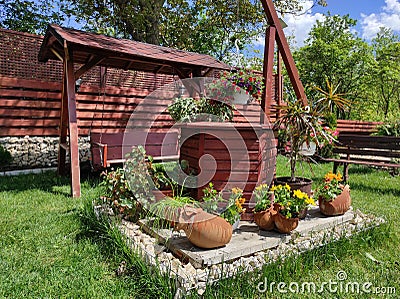 Decorative well with blossomed flower pots Stock Photo