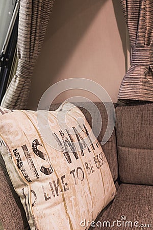 Decorative white pillow with brown characters on a couch in a ca Stock Photo