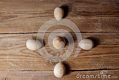 Decorative wooden eggs laid out in an unusual way on a rustic table. symbolic holiday composition for gift card. copy space. close Stock Photo