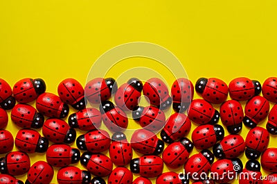 Decorative wooden ladybugs on yellow background with copy space. Ladybug pattern Stock Photo