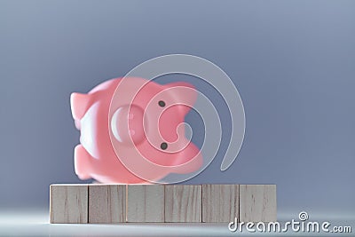 Decrease in income. Financial crisis. Bank Default and bankruptcy. Turn over piggy bank on wooden cubes Stock Photo