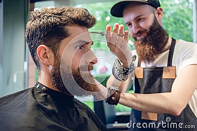 Dedicated hairstylist using scissors and comb Stock Photo