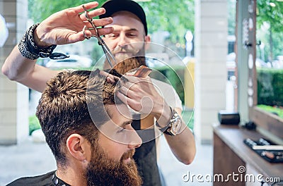 Dedicated hairstylist using scissors and comb while giving a coo Stock Photo