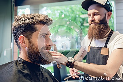 Dedicated hairstylist using scissors and comb while giving a coo Stock Photo