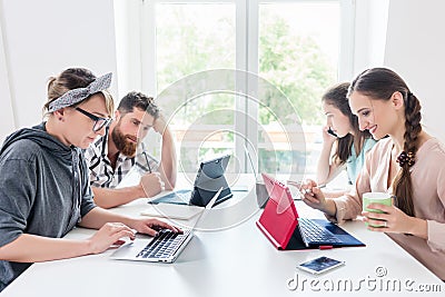 Dedicated young woman editing a document in a modern office space Stock Photo