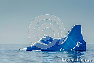 Deep blue Iceberg floats in the Arctic sae, melting Stock Photo