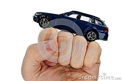 Deep blue metallic model of modern wagon car placed on raised fist of adult male person, white background Stock Photo