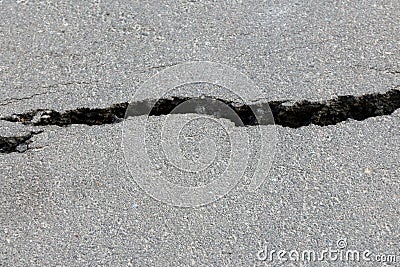 Deep crack in the asphalt road. danger to people and vehicles. Stock Photo