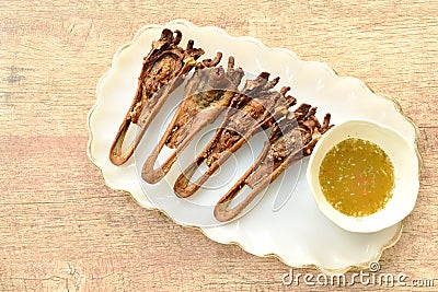 Deep fried duck beak dipping spicy sauce on plate Stock Photo