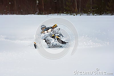 In deep powder snowdrift snowmobile rider make fast turn Stock Photo