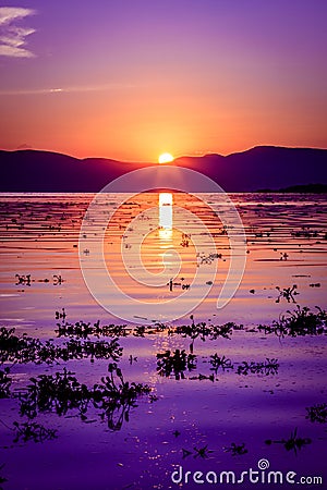 Deep majestic purple sunset reflecting over a rippled Lake Chapala in Ajijic Mexico Stock Photo