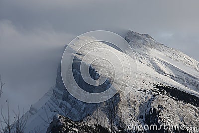 Deep Snow blowing off the top of a mountain ridge in the rockies Stock Photo