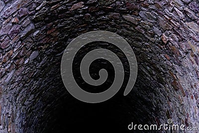 Deep stone well, old dungeon, concept of ancient castle communications, underground prison, history of human settlements Stock Photo