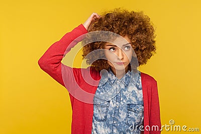 Deep in thoughts. Portrait of pensive confused woman with curly hair in casual outfit scratching head, wondering Stock Photo