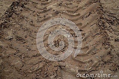 Deep trace tractor wheel in brown sand, dirt road Stock Photo