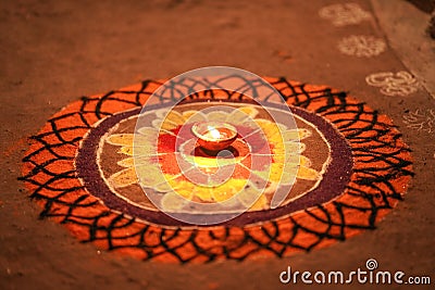 Diwali celebration - Diya oil lamps lit on colorful rangoli, Indian festival diwali and colourful rangoli and diya in centre Stock Photo