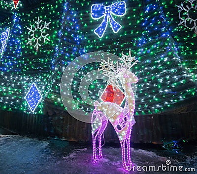 Deer with bright lights and decorated fir. Editorial Stock Photo