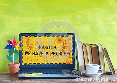 Defect laptop computer in home office, displaying message Houston We Have A Problem Stock Photo