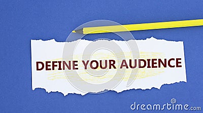 DEFINE YOUR AUDIENCE - word on a torn white paper on a blue background Stock Photo