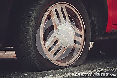 Deflated car wheel tire on wrecked car Stock Photo