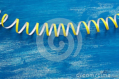 Defocus is a detailed image of colorful streamers serpentine on a wooden blue vintage background. Stock Photo