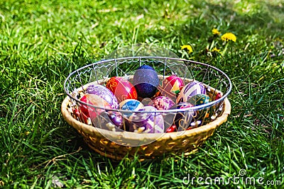 Defocus multicolored easter eggs. Decorated pysanka and krashanka. Wooden Basket With Easter Eggs In The Green Grass. Close-up. Stock Photo