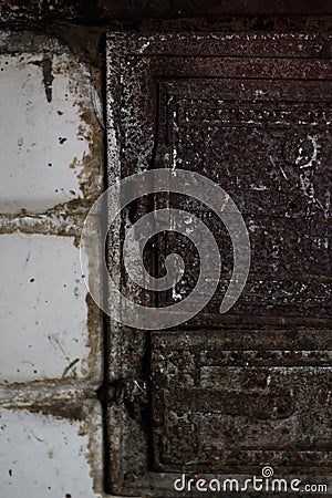 Defocus Old stove doors. Iron door close-up detailed decor in antique house. Vertical. Dirty brick. Out of focus Stock Photo