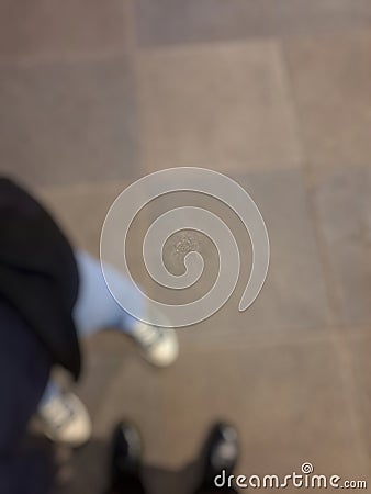 Defocused abstract background of two pairs of feet wearing different shoes. Stock Photo