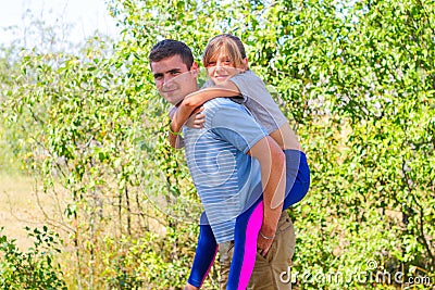 Defocused brother giving sister ride on back in park. Portrait of happy girl on young man shoulders, piggyback. Family playing Stock Photo