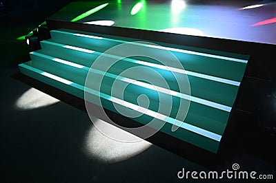 Defocused view of staircase to empty stage with multicolor spotligt rays Stock Photo