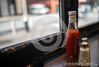 Ketchup bottle salt shaker and black evening bag in a diner window Stock Photo