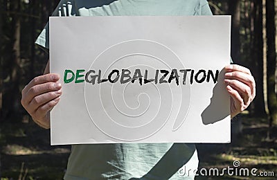 Deglobalization and reverse globalization concept. Word on paper placard in male hands with forest background Stock Photo