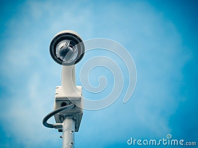 360 Degree fish eye dome CCTV is installed on column against blue sky. Stock Photo