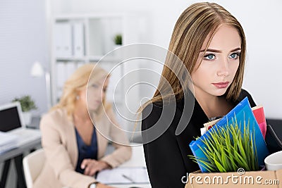 Dejected fired office worker carrying a box full of belongings Stock Photo