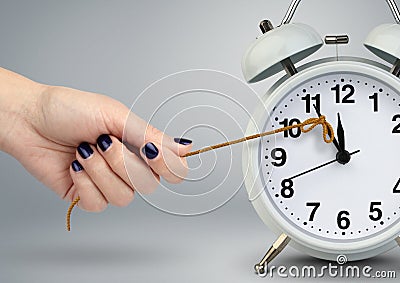 Delay concept, time on alarm clock stop by hand Stock Photo