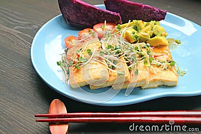 Grilled Tofu and Fresh Daikon Microgreens Salad with Steamed Purple Sweet Potatoes Stock Photo