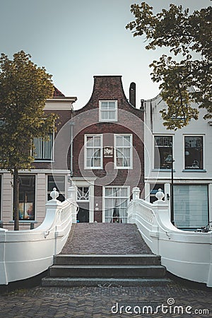 Canal house in Delft and beautiful white bridge on the Voorstraat Editorial Stock Photo