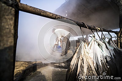 Delhi, India- January 12 2022- Indian men making jaggery, jaggery traditional non-centrifugal sugar consumed in India. Man Editorial Stock Photo