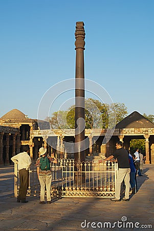 Tourists visit the Iron Pillar at the Qutb Minar complex in Delhi, India. Editorial Stock Photo