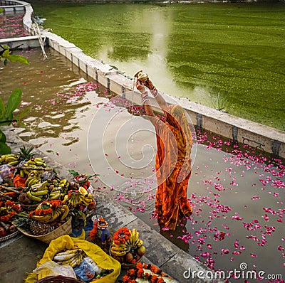 Delhi, India: 13 November 2021- Indian woman celebrating chhath pooja by submerging in the water, indian woman wearing traditional Editorial Stock Photo