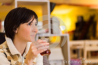 Delicate caucasian woman with short brown hair holding a glass of tea. Stock Photo