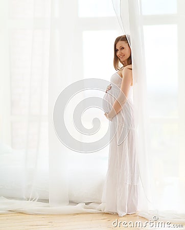 Delicate elegant pregnant woman in a white dress Stock Photo