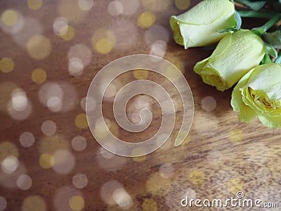 Delicate floral corner frame with yellow roses, wooden background bokeh Stock Photo