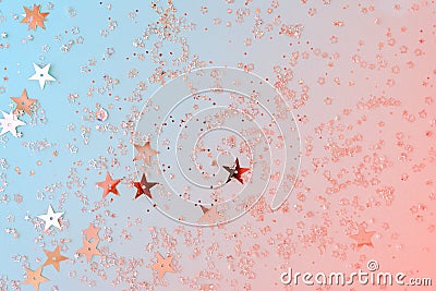 Delicate glitter star confetti on coral and blue background. Creative and moody color of the picture Stock Photo