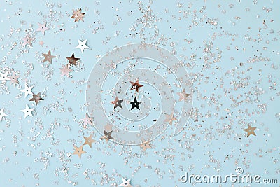 Delicate glitter star confetti on light blue background. Creative and moody color of the picture Stock Photo