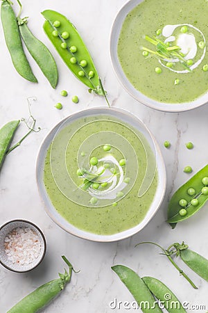 Delicate spring green cream soup with green peas and mint, white background. Spring or summer vibrant healthy vegetarian menu Stock Photo